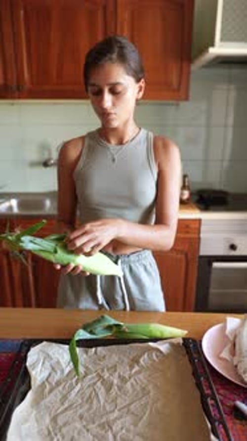 Young Woman Preparing Corn in Kitchen Indoors