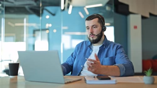 Man Working at Computer With Headset On