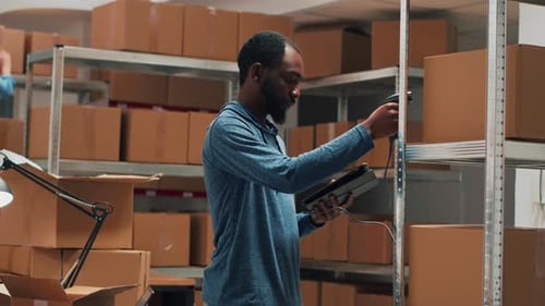 Male Entrepreneur Using Scanner and Tablet to Check Supplies Inventory