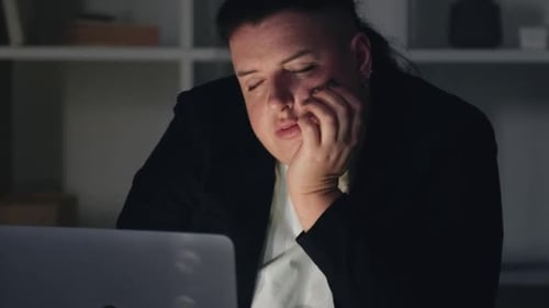 Sleepy Person Working at Laptop Late at Night