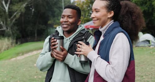 Camping, coffee and couple relax in a forest, happy and talking while bonding in nature