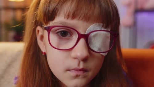 Child with Eye Patch Wearing Glasses Indoors