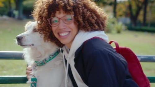 Woman Cuddling Dog on Park Bench, Smiling