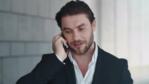 Man in Suit Smiling During Phone Call
