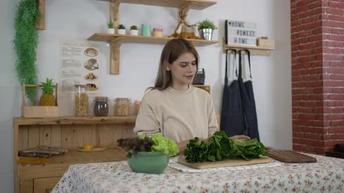 Young Woman Prepares Fresh Lettuce in Kitchen