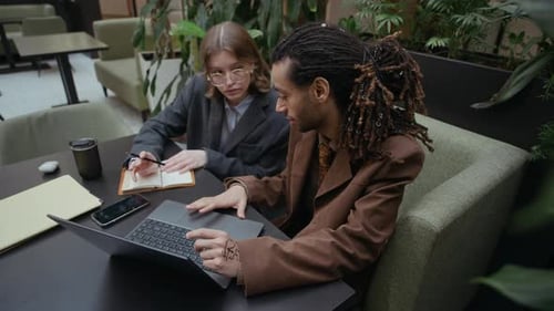Un couple d'affaires créatif de la génération Z réfléchit dans un espace de coworking vert