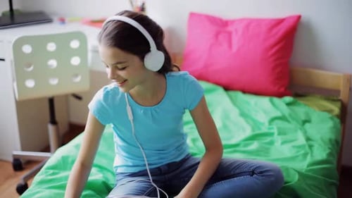 Girl Listening to Music on Headphones at Home