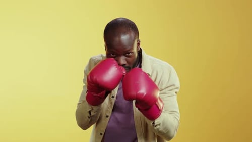 Man Posing in Boxing Gloves with Serious Expression