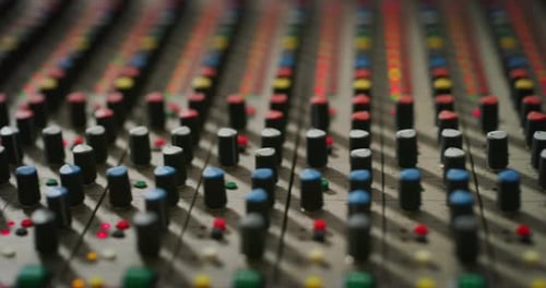 Macro slide shot of a sound producer hand is using a music mixer with editing tools in a professio