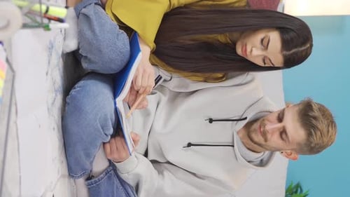 Vidéo verticale d'un jeune couple d'étudiants heureux étudiant à la maison.