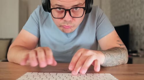 Man With Headphones Types on a Keyboard
