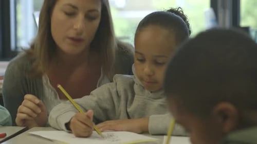 MS R/F PAN Mid Adult teacher and school children drawing in classroom