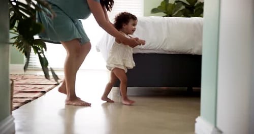 Mother Helping Toddler Walk in Bedroom