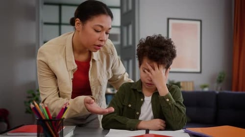 Worried Boy Doing Homework with Mother's Help