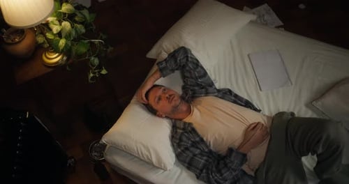 Man Lying on Bed Looking at Ceiling