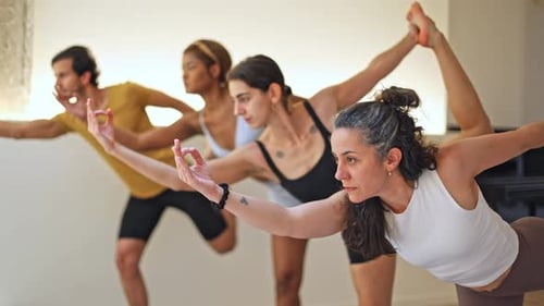 Group of Adults Practicing Yoga Poses Indoors