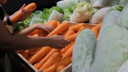 Mother with Daughter Buying Carrots at Grocery