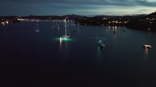Aerial Drone View of Harbor with Illuminated Boats at Night