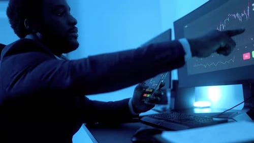 Business African trader investor using stock exchange market app on mobile inside office at night