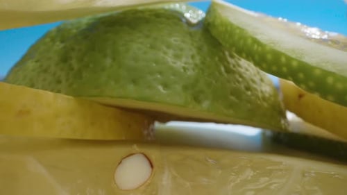 The camera rides inside sliced lemon slices. Dolly slider extreme close-up.