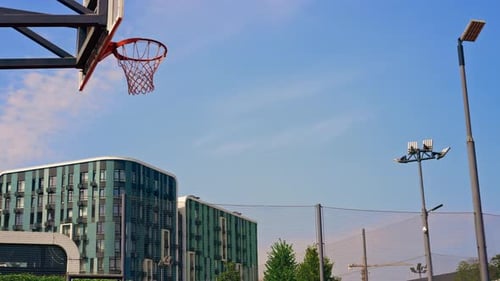 Un joueur de basket de grande taille saute sur le cerceau avec le ballon en main pour marquer un dunk spectaculaire