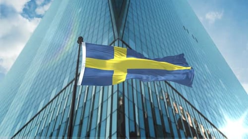 Waving Swedish Flag Against Modern Corporate Building