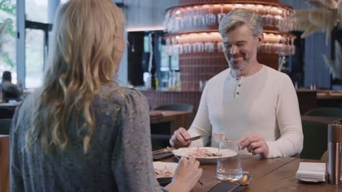 Couple Sitting Indoors in Restaurant Talking Have Dinner Man and Woman Have Relax Time Date Modern