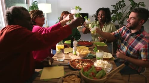 slow motion while a group of friends toast with mojitos celebrating a weekend meal