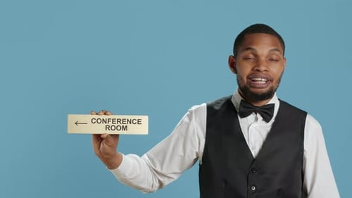 Man Holding Conference Room Sign on Blue Background