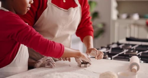 Child and Adult Baking Cookies Together in Kitchen
