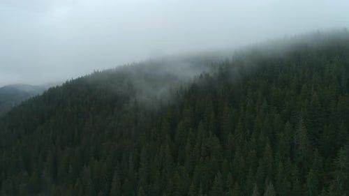 Flying through the clouds above mountain tops.