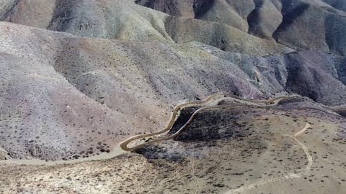 Dirt road contours remote undeveloped arid hillsides in rural Chile