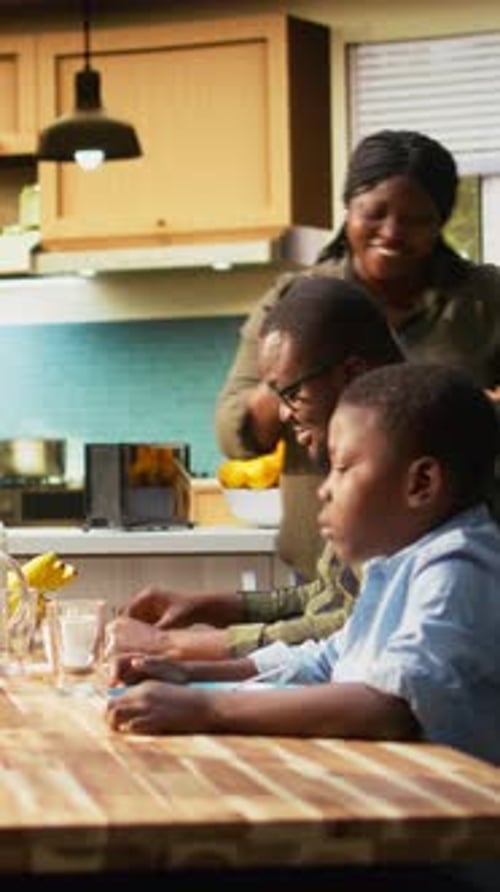 Family Meal: Mother serving food to son, father