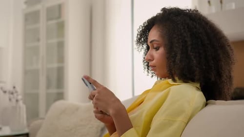 Woman Relaxing at Home Using Smartphone