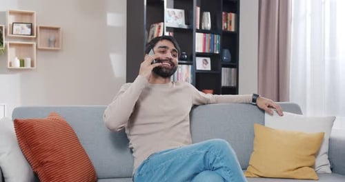Smiling Man Talking on Phone at Home