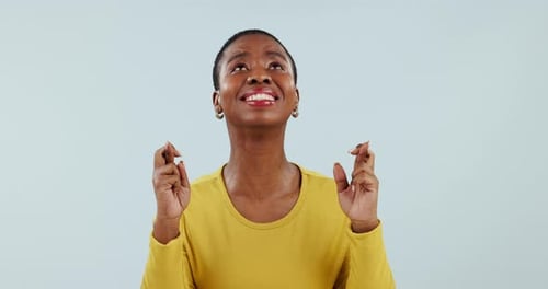 Fingers crossed, woman and hope for success in studio, waiting for luck