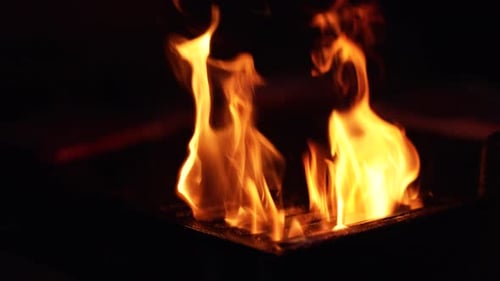 Ein Feuer für die Zubereitung des Grills in Zeitlupe.