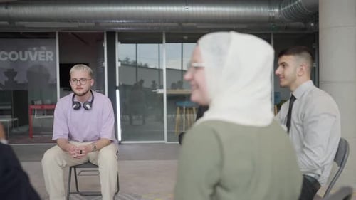 A Diverse Group of Young Business Entrepreneurs Gathered in a Circle for a Meeting Discussing