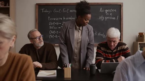 Teacher Helps Seniors Learn Computer Skills in Classroom