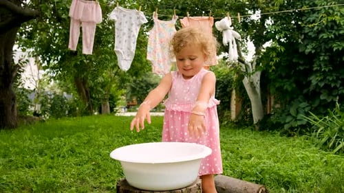The Child is Washing Clothes in the Garden Selective Focus