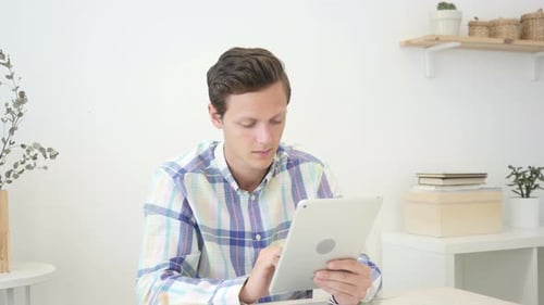 Young Adult Working on Tablet Indoors