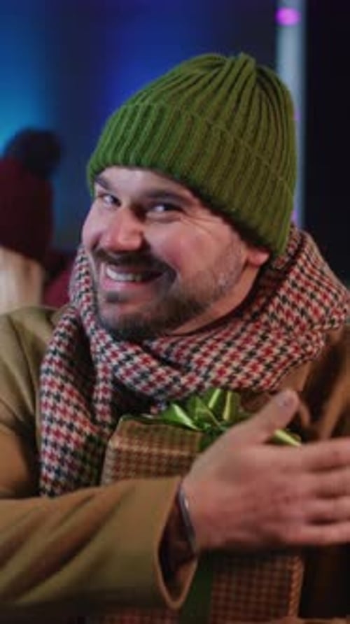 Smiling Man Holding Christmas Present at Night
