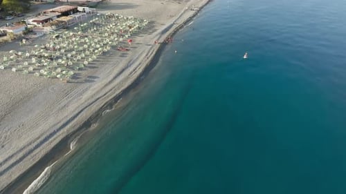 Blue Mediterranean Ocean In Summer Season With Umbrellas On The Beach