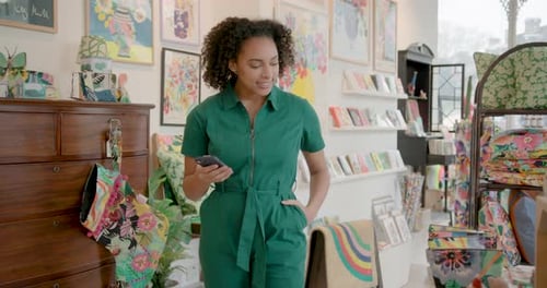 Black Young Adult Female Shopping in Store, holding Phone