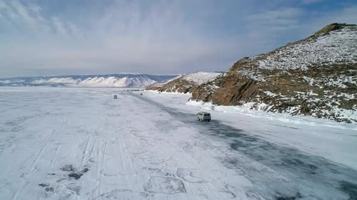 Aerial View on Tourist Cars Driving on Cracked Ice of Baikal to the Famous Tourist Spot Winter