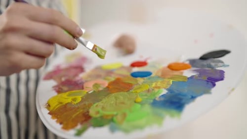 Artist Mixing Colors on Palette Closeup View in Art Workshop of Female Master Fine Art and Drawing