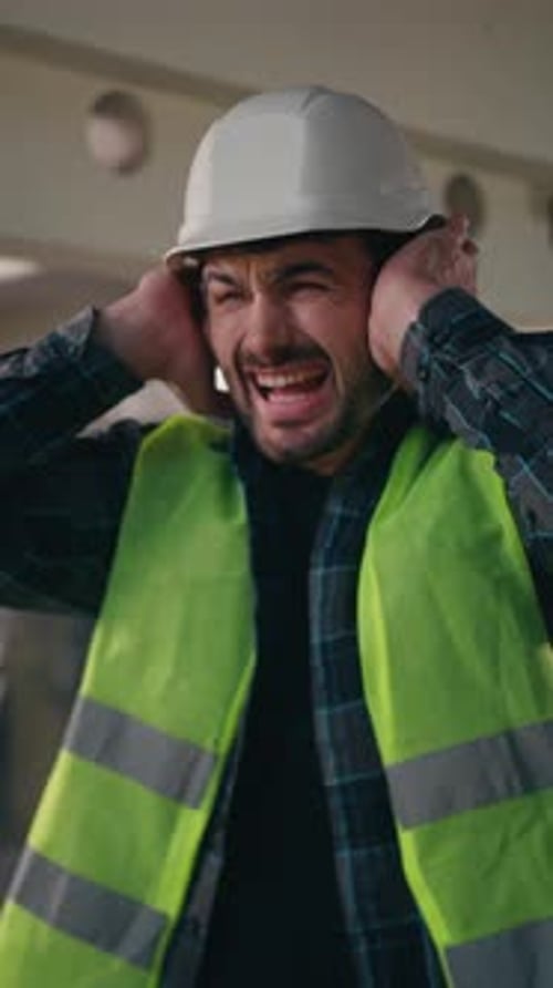 Construction Worker Covering Ears Grimacing