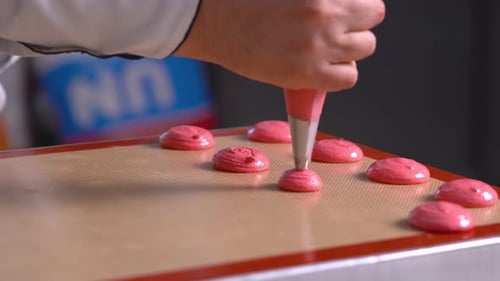 Piping Pink Macaron Batter on Baking Sheet