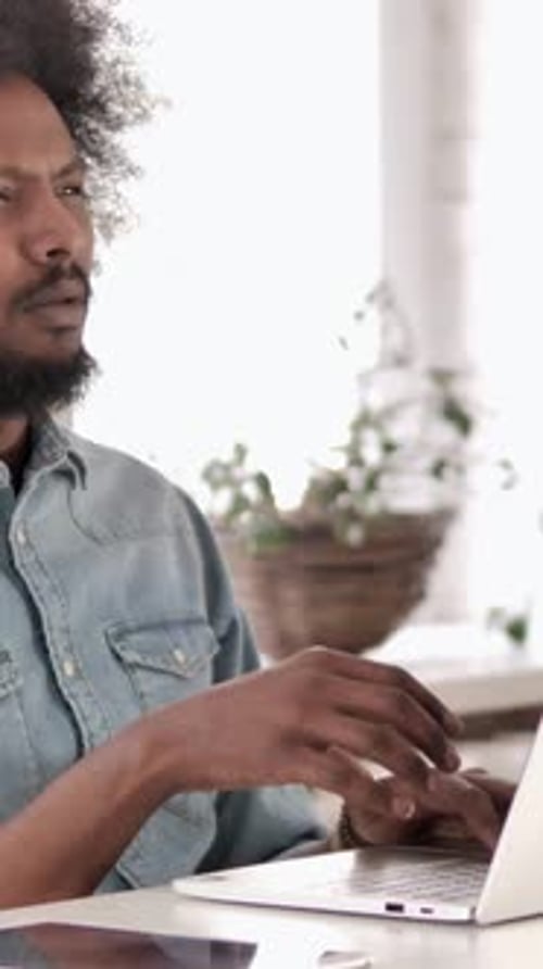 Man Using Laptop in Bright Indoor Home Setting