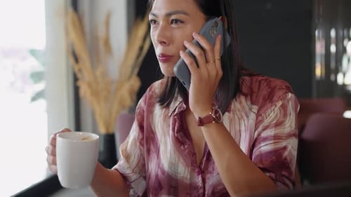 Female Entrepreneur Having Call when Drinking Coffee in Cafe
